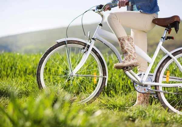 Πόδια της γυναίκας σε μπότες ιππασίας με το ποδήλατό — Φωτογραφία Αρχείου