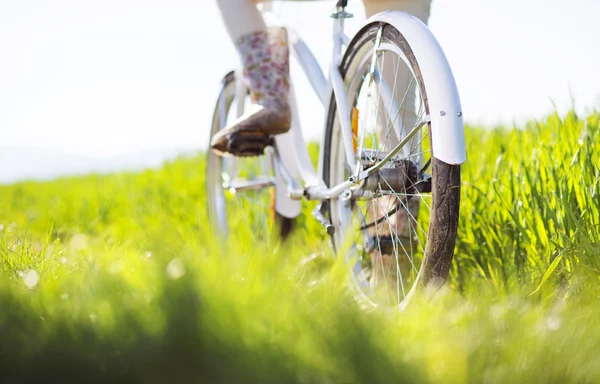 Vrouw voeten in laarzen rijden op fiets — Stockfoto