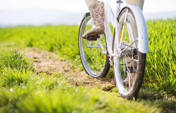 Pies de mujer en botas montadas en bicicleta — Foto de Stock