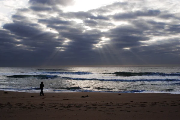 Man går till havet på mörka strand — Stockfoto