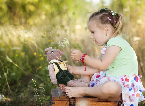 Dívka sedí s hračkami — Stock fotografie