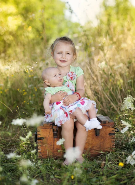 Girl holding her baby sister — Stock Photo, Image