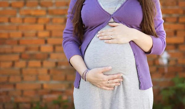 Schwangere hält ihren Bauch — Stockfoto