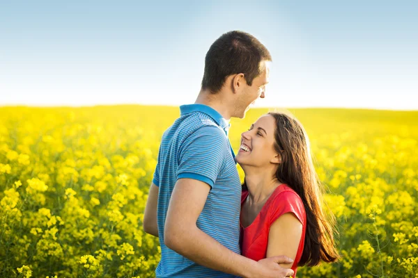Para przytulanie w żółtym polu — Zdjęcie stockowe