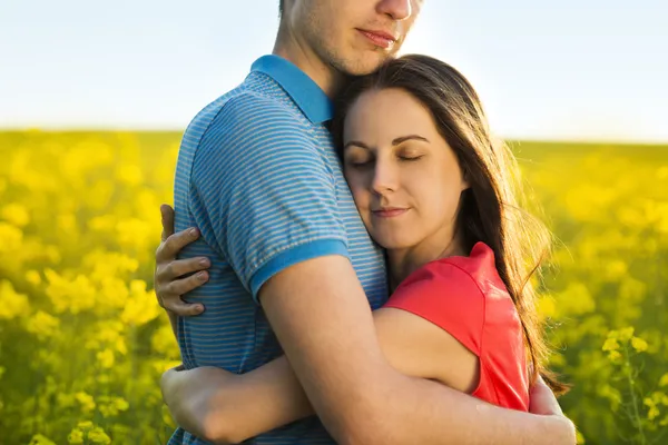 Paar umarmt sich in gelbem Feld — Stockfoto