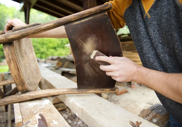 Mannelijke handen te verwijderen verf vanuit stoel — Stockfoto