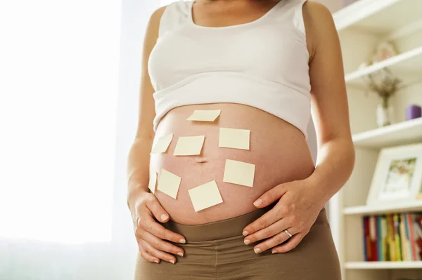 Mulher grávida com notas pegajosas — Fotografia de Stock