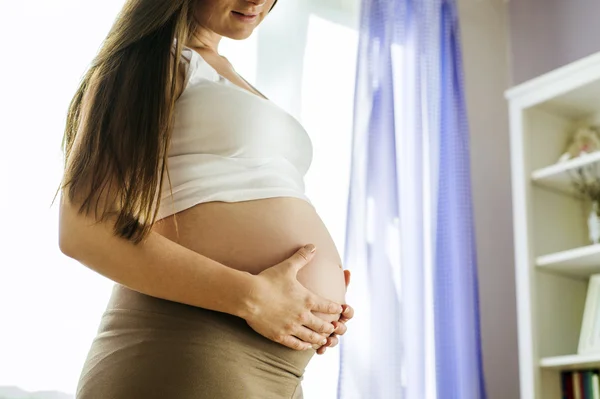 Frau mit Händen über dem Bauch — Stockfoto