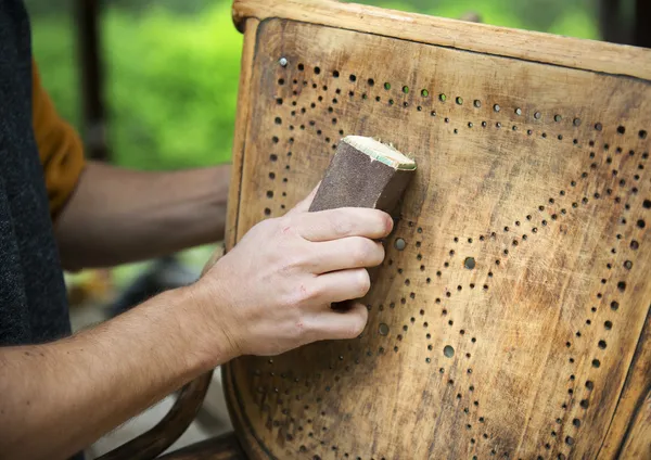 Male hands removing paint from chair — Stock Image Male hands removing paint from chair Stock Photo