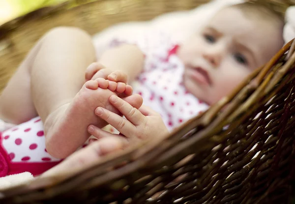 Baby girl lying down in basket — Stock Photo, Image