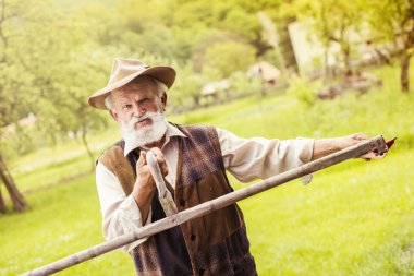 çiftçi onun tırpan hazırlanıyor