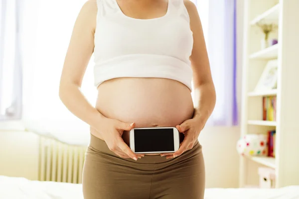 Gravid kvinna med mobiltelefon — Stockfoto