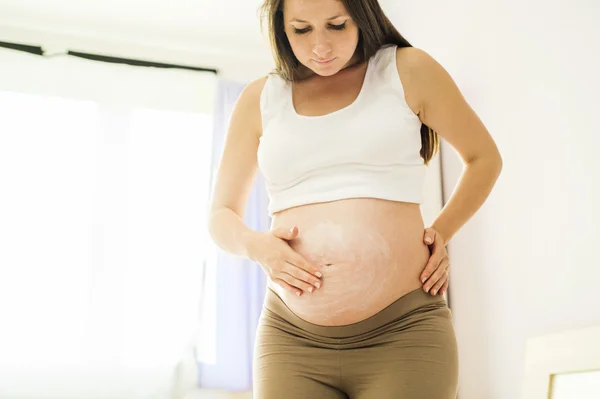 Mujer aplicando crema hidratante — Foto de Stock