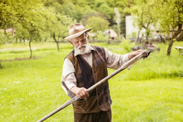 Çiftçi onun tırpan hazırlanıyor — Stok fotoğraf