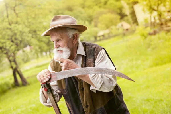 Agricultor preparando su guadaña — Foto de Stock