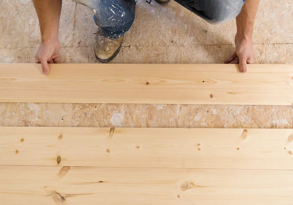 Handyman instalando piso de madera — Foto de Stock
