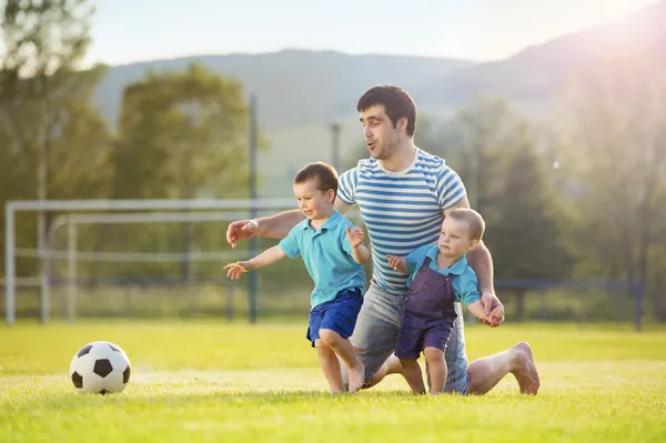 Père avec des fils jouant au football — Photo