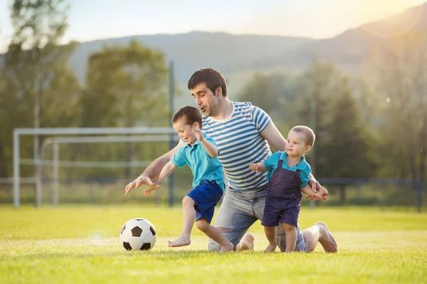 Padre con hijos jugando al fútbol —  Fotos de Stock