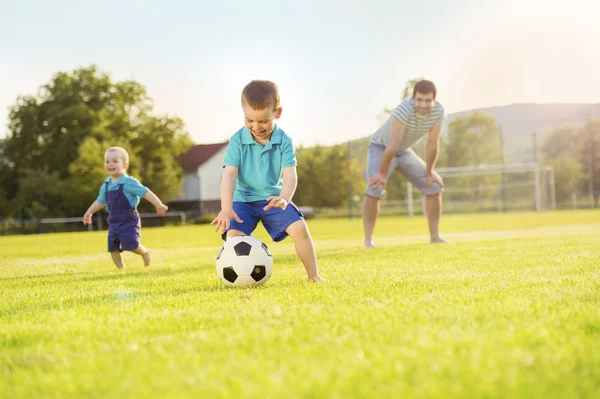 Vader met zonen voetballen — Stockfoto
