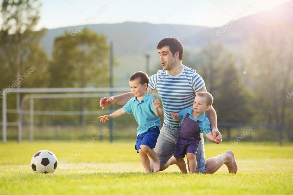 Father with sons playing football
