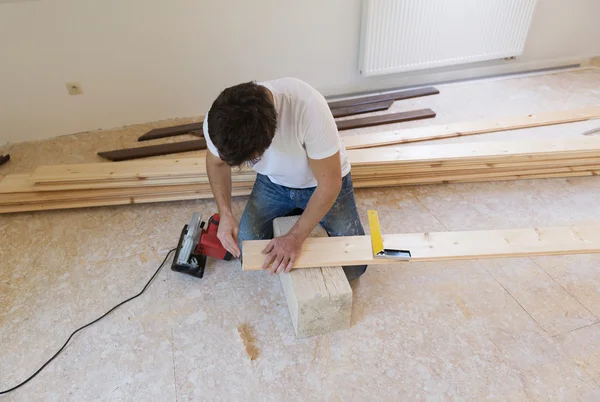 Handwerker verlegt Holzboden — Stockfoto