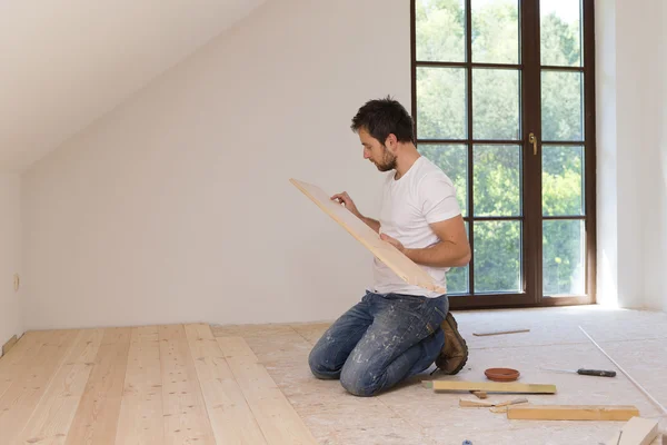 Handyman instalar piso de madeira — Fotografia de Stock