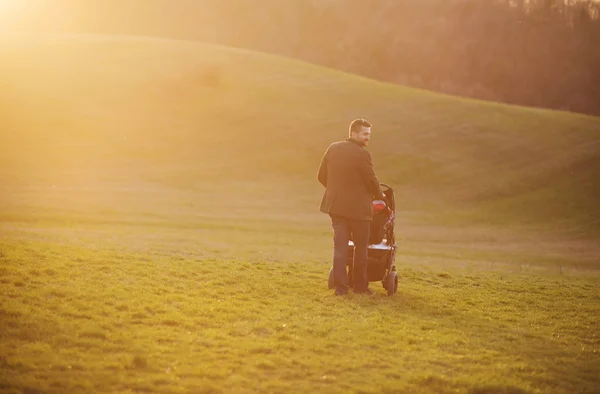 Far med barnvagn under promenad — Stockfoto