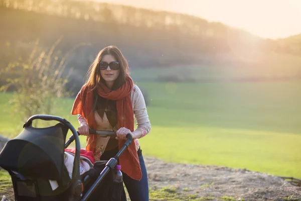 Ung mamma med barnvagn — Stockfoto