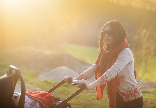 Ung mamma med barnvagn — Stockfoto