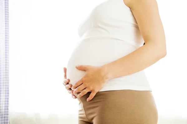 Zwanger vrouw houden haar buik — Stockfoto