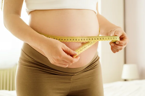 Pregnant woman measuring her belly — Stock Photo, Image