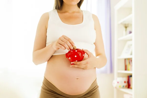 Frau hält Sparschwein — Stockfoto