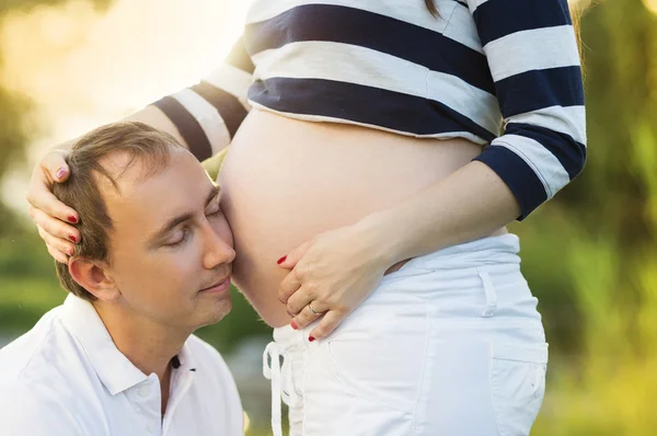 Man kussen zwangere buik — Stockfoto