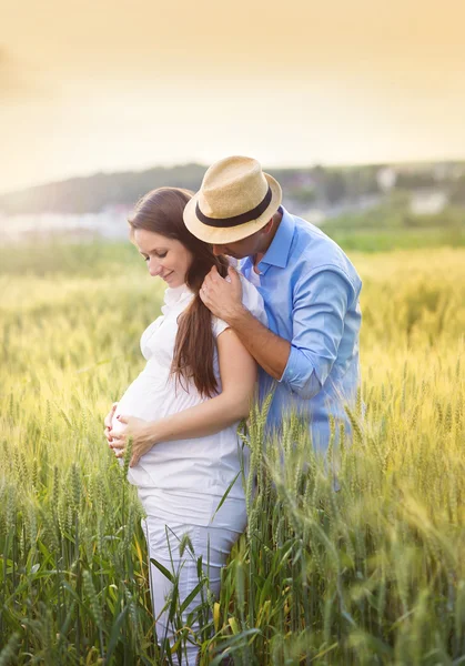 Zwangere paar in veld — Stockfoto