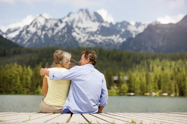 Senior couple sitting on pier — Stock Photo, Image