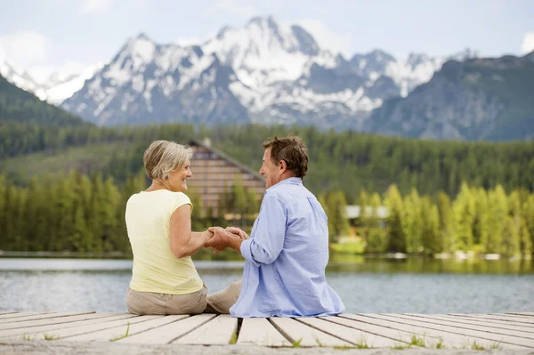 Senior couple sitting on pier — Stock Photo, Image