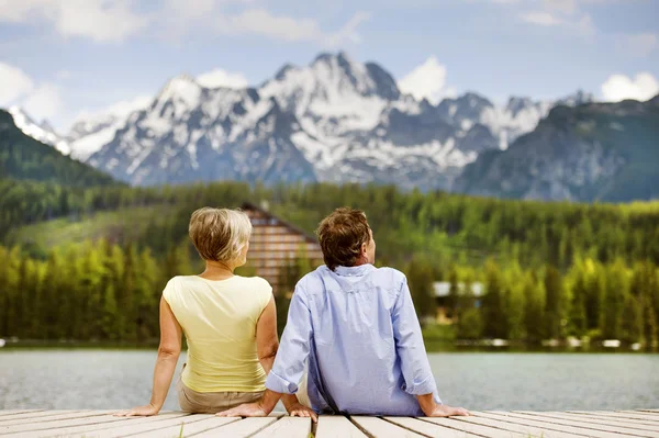 Senior koppel zittend op de pier — Stockfoto