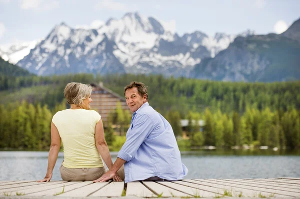 Senior couple sitting on pier — Stock Photo, Image