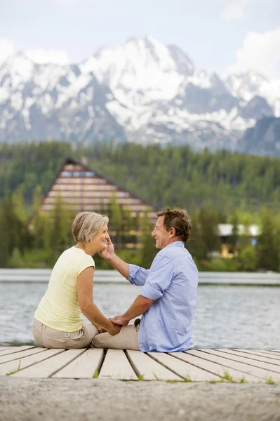 Senior couple sitting on pier — Stock Photo, Image