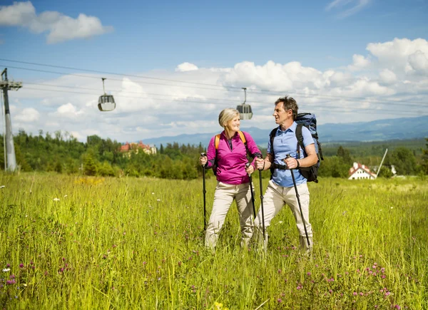 Couple hiking under cableway — Stock Photo, Image