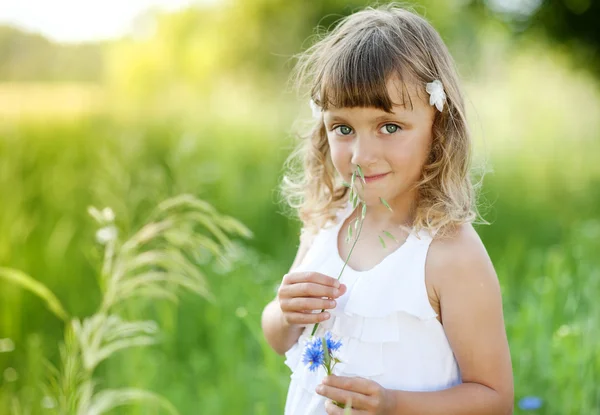 Liten flicka med blommor — Stockfoto