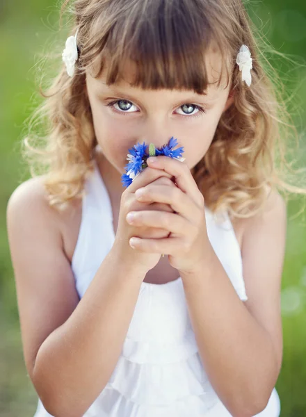 Kleines Mädchen mit Blumen — Stockfoto