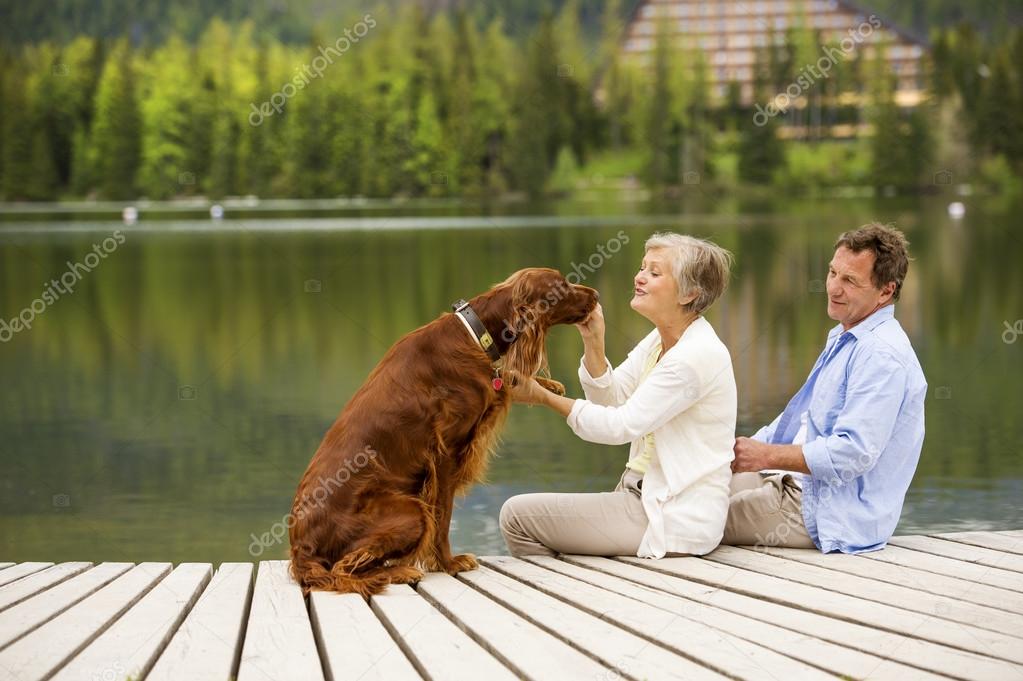 Couple with dog sitting on pier