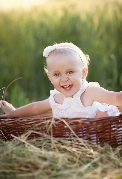 Meisje, zittend in mand — Stockfoto