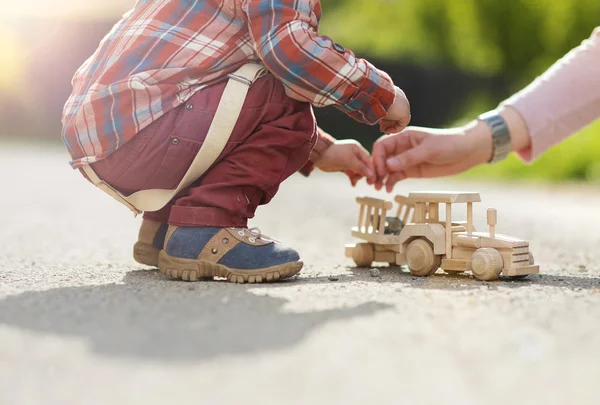 Boy playing with wooden tractor — Stock Photo, Image