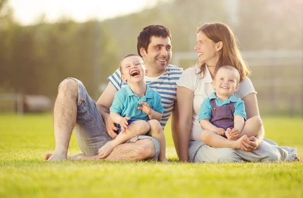 Familia sentada en campo de fútbol — Foto de Stock