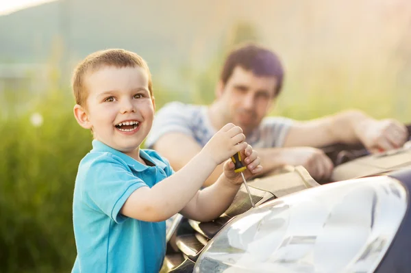 Отец с сыном ремонтирует машину — стоковое фото