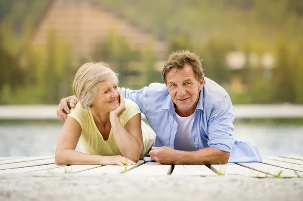 Seniorenpaar amüsiert sich auf Seebrücke — Stockfoto