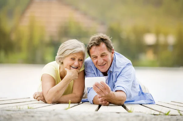 Senior couple lying on pier — Stock Photo, Image