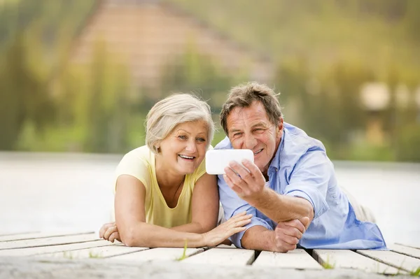 Senior couple lying on pier — Stock Photo, Image